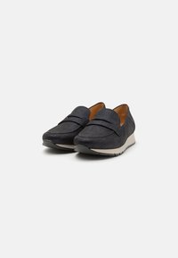 Svarta texturerade loafers med låg kilklack, med en slät överdel på framsidan och en polstrad insida för komfort.