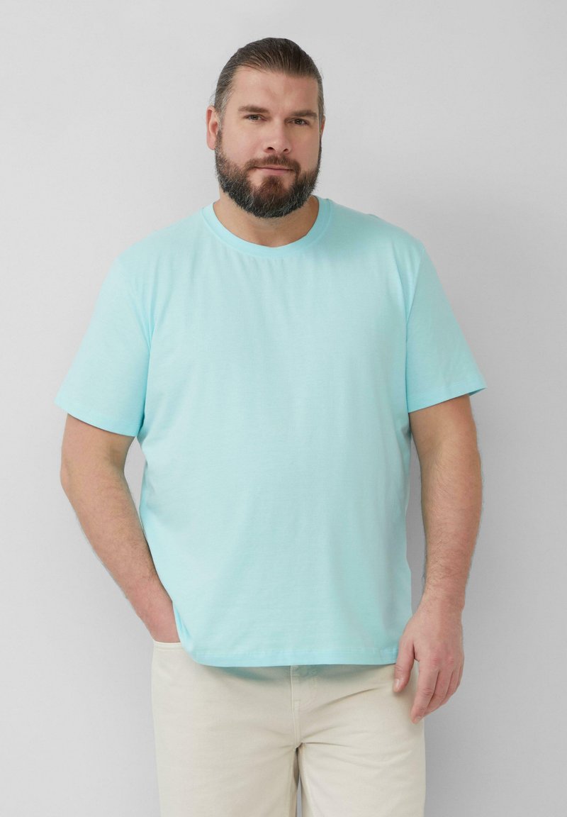 Lichtblauwe t-shirt met korte mouwen van zachte katoenstof, met een ronde halslijn en een relaxte pasvorm, gecombineerd met lichtgekleurde broek.