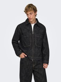 Veste en denim foncé avec une fermeture éclair frontale, deux poches poitrine et des coutures contrastantes. Tissu texturé avec une coupe décontractée.