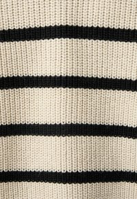 Tejido de suéter de punto en crema con llamativas rayas horizontales negras. Presenta un tejido grueso y texturizado con patrones de puntadas visibles.