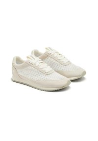 Zapatillas deportivas ligeras con parte superior de malla blanca, acentos de ante crema, cordones planos y suela de goma texturizada con un leve tacón.