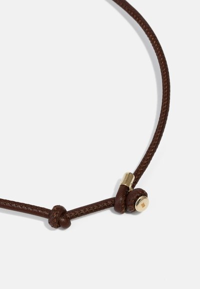 Collana in pelle intrecciata marrone con accessori in tonalità oro e un dettaglio a nodo, caratterizzata da una texture liscia e un design minimalista.