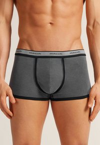 Szare slipy bokserskie z miękkiej tkaniny z kontrastującym czarnym pasem. Zawierają konturowany kieszeń oraz szyte boczne szwy.