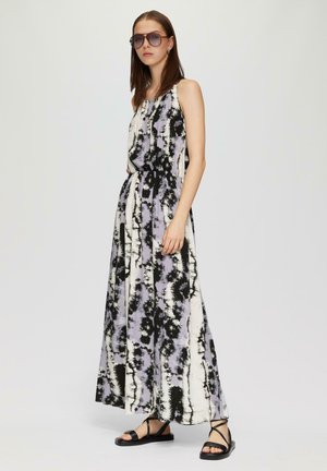 Maxikleid im Schwarz-Lavendel-Tie-Dye-Muster, mit lässiger Passform, ärmellosem Design und Stoffgürtel. Kombiniert mit schwarzen Sandalen.