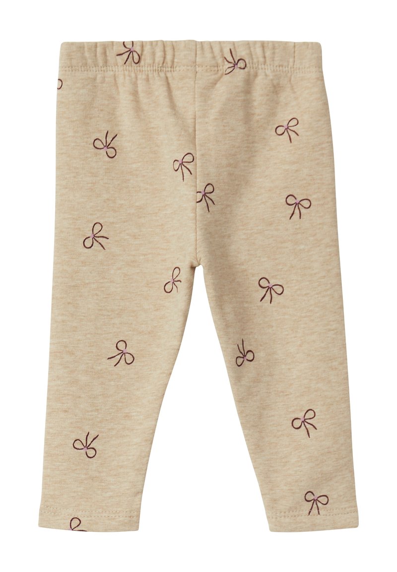 Beige leggings van zachte stof, met een herhalend patroon van kleine paarse strikjes. Elastische tailleband aan de bovenkant.