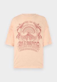 Camiseta de algodón color durazno con un gran diseño gráfico que incluye palmeras, un sol y texto. Corte relajado con mangas cortas y cuello redondo.