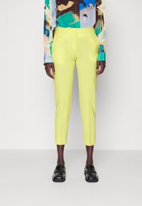 Slimfit, klara gula byxor med en jämn textur, avkortad längd och skräddarsydd midja. Tillsammans med en färgglad, mönstrad skjorta.