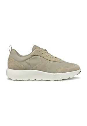 Baskets de sport beiges en matériaux mesh et suède, avec une semelle blanche arrondie et un laçage à l'avant. Présente un logo discret et une languette au niveau du talon.