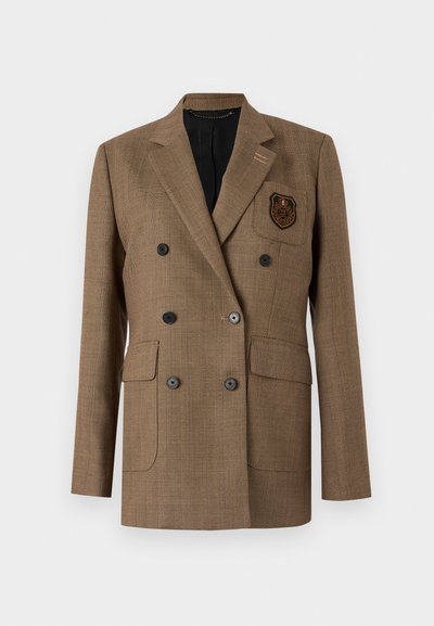 Jachetă maro cu împletitură în formă de V, cu două buzunare frontale, butoane negre și o pată pe piept. Croială ajustată cu un design clasic al reverului.