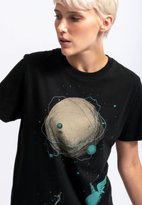 Zwart katoen t-shirt met een ruimtethema, featuring een grote planeet, kleinere planeten en sterpatronen in teal, rood en beige.