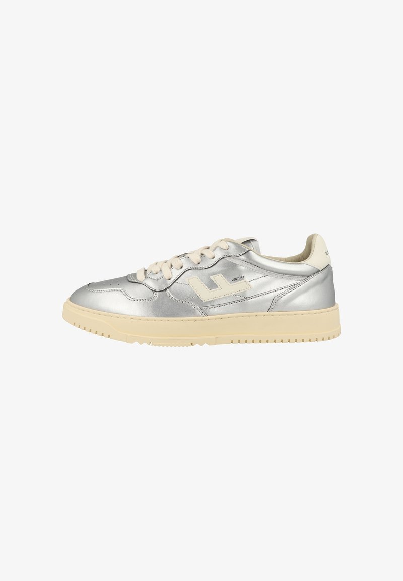 Sneaker argento low-top con suola e lacci beige, caratterizzata da un logo laterale e un colletto imbottito.