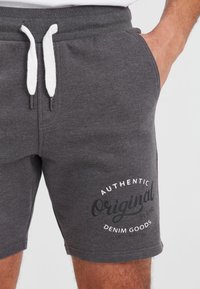 Gray cotton blend shorts with an elastic waistband and white drawstring. Features printed text "Authentic Original Denim Goods." Smooth texture.