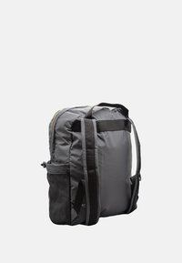 Zaino in tessuto grigio con forma rettangolare, dotato di spallacci neri, una tasca laterale e dettagli accentuati discreti. Tessuto morbido e resistente.