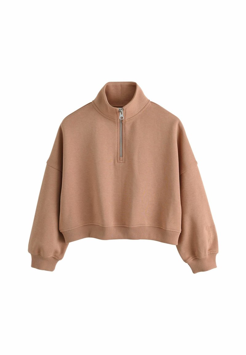 Pull en laine surdimensionné et découpé, fabriqué en tissu texturé et côtelé de couleur beige doux. Il présente un col à demi-zip et de longues manches bouffantes.