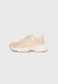 Scarpa sportiva beige con tomaia in rete e sintetico, punta rotonda e suola bianca spessa. Presenta un dettaglio del logo e lacci di colore chiaro.