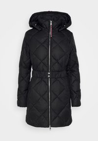 Black quilted puffer jacket with a hood, featuring a zip front, elastic waist belt, and metallic accents. Soft, smooth fabric texture.
