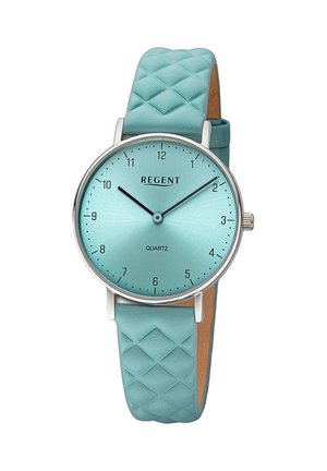 Montre en quartz ronde avec un cadran texturé bleu clair, des aiguilles en acier inoxydable et un bracelet en cuir matelassé assorti. Dispose d'un design minimaliste.