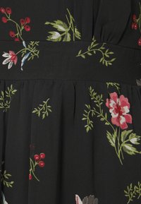 Robe en tissu noir ornée d'une broderie florale vibrante en rouge, rose, vert et bleu. Comprend des plissés à la taille et une texture lisse.