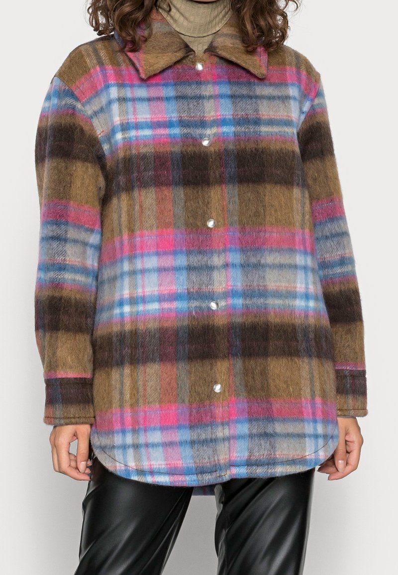 Camisa chaqueta de botones de cuadros en marrón, rosa, azul y gris, hecha de lana texturizada, con cuello puntiagudo y dobladillo redondeado.