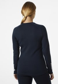 Marinefarbene Sportbekleidung mit langen Ärmeln, taillierter Passform, glatter Textur und weißen Streifenakzenten an den Ärmeln.