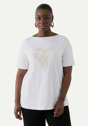 T-shirt en coton blanc avec un imprimé de fougère dorée au centre. Le haut a des manches courtes et un col arrondi, associé à un pantalon noir.