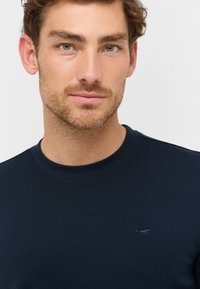 Marineblaue Rundhals sweatshirt aus geripptem Baumwollstoff, mit einem kleinen, gestickten Pferdelogo auf der linken Brust.