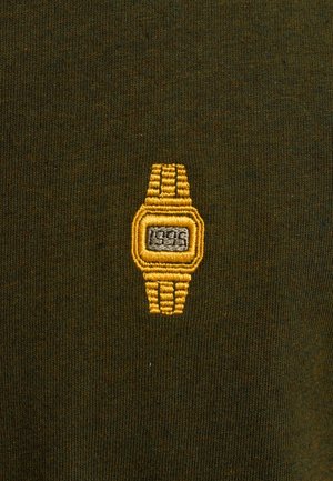 Groene stof met een klein geel geborduurd horlogedesign, met een rechthoekige wijzerplaat en textuurdetails op de band.