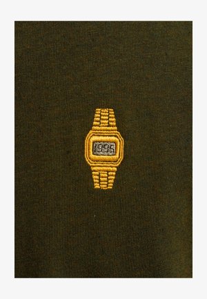 Green fabric features a small yellow embroidered watch design, with a rectangular face and textured strap details.