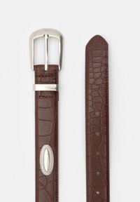 Bruine faux krokodillenleren riem met een zilverkleurige metalen gesp en een ovale bevestigingsdetail. Heeft meerdere aanpassingsgaten.