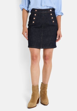 Jupe en jean noir avec une coupe ajustée, présentant cinq boutons décoratifs en cuivre et des coutures discrètes, se terminant juste au-dessus du genou.