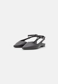 Bailarinas negras de cuero con talón descubierto y puntera afilada, diseño minimalista, correa ajustable con hebilla y tacón bajo para mayor comodidad.