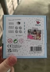 Zestaw do gotowania dla dzieci w jasnoniebieskim pudełku; zawiera przybory kuchenne, koronę i okrągłe talerze. Na opakowaniu znajduje się małe zdjęcie dzieci przy stole. Wysokość: 1,2 cm.