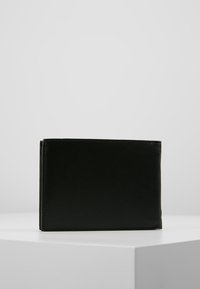 Portefeuille en cuir noir avec une texture lisse, design pliant, bords cousus et forme rectangulaire compacte.