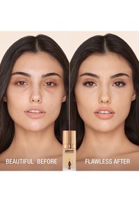 Before-and-after comparison of a face, showcasing smoother skin on the right. Centered product is a foundation in a clear bottle with gold accents.