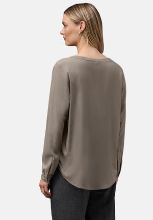 Blusa de manga larga en topo con escote redondo, textura suave y puños abotonados. Vista desde la espalda, con un ligero brillo.