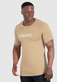Beige, figursydd t-shirt med kort ärm med "SMILODOX" tryckt i vitt på framsidan. Slät tygkvalitet med rund hals och raglanärmar.