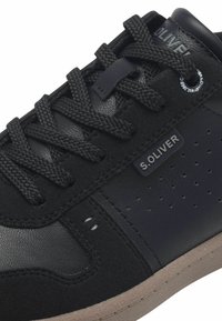 Mustad must sussidest ja sünteetilisest materjalist valmistatud mustad tossud, millel on tekstuuriga paelad, külg-logo, perforatsioonid ning kummist outsole.
