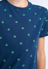 Tricou bleumarin din bumbac moale, cu un model de mici soare și valuri verzi distribuite uniform pe material.