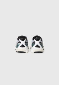 Black and white athletic shoes with mesh upper, rounded shape, contrasting teal accents, and a textured rubber sole.