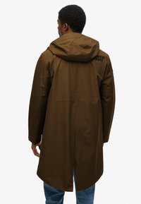 Brązowy wodoodporny parka z kapturem, prostym krojem i tylnym wentylem. Posiada detal z logo z tyłu oraz wygodny design rękawów.