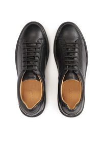 Zapatillas de piel negra con punta redonda, diseño de cordones y textura lisa. El interior cuenta con un acolchado marrón claro con una marca sutil.