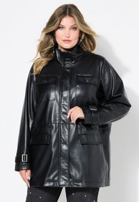 Giacca in ecopelle nera con colletto alto, due tasche anteriori e polsini con cintura. Il design è elegante con una finitura lucida.