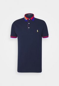 Mörkblå polo-shirt med en flerfärgad krage och ärmslut. Har en broderad gul logotyp på bröstet och en knäppning med tre knappar.