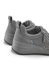 Gray suede sneakers with a textured side panel, padded collar, zip closure, and a chunky platform sole. Features smooth and matte finishes.