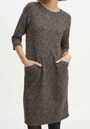 Vestido de estampado de leopardo marrón con mangas tres cuartos, escote redondeado y dos bolsillos frontales. Material suave y corte holgado.