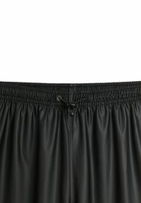 Svarta shorts med elastisk midja och dragsko-stängning. Tillverkade av ett slätt, glänsande material med en rynkad textur.