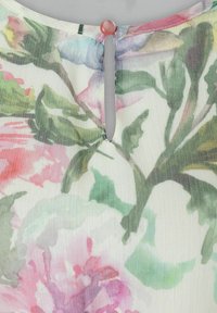 Bluse mit Blumenmuster aus leichtem, transparentem Stoff. Verfügt über eine Schlüsselöffnung am Rücken, die mit einem hellrosa Knopf befestigt ist.