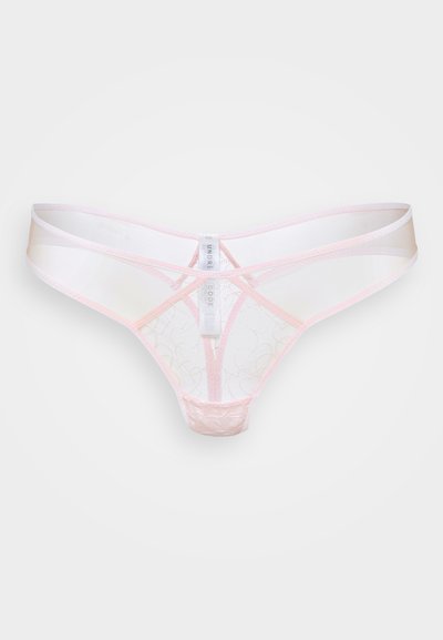 Prozirni svijetloružičasti čipkasti donji veš u obliku tangi s valovitim šavovima i središnjim bijelim oznakom koja prikazuje detalje marke.