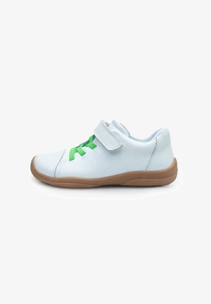 Witte leren schoen met groene veters, een klittenbandsluiting en een bruine rubberen zool; ronde vorm, gladde textuur en minimalistisch ontwerp.