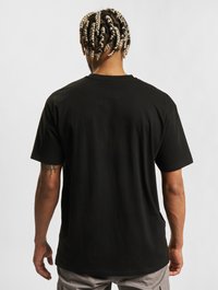 Czarny bawełniany t-shirt o luźnym kroju, z krótkimi rękawami i okrągłym dekoltem. Charakteryzuje się gładką fakturą i prostym designem.